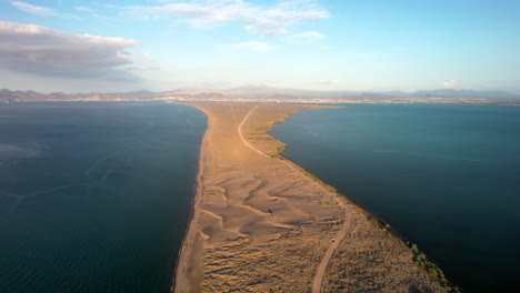 Orbital-drone-shot-of-the-road-that-leads-to-the-sandboarding-area-in-the-dunes-of-mogote-in-baja-california-sur-mexico