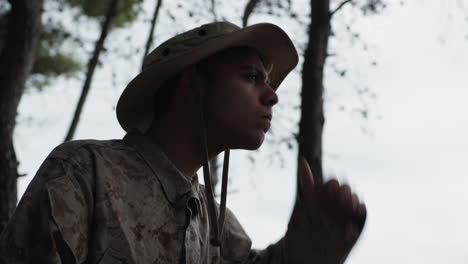 military guy looks suspiciously at the enemy in the forest at daytime