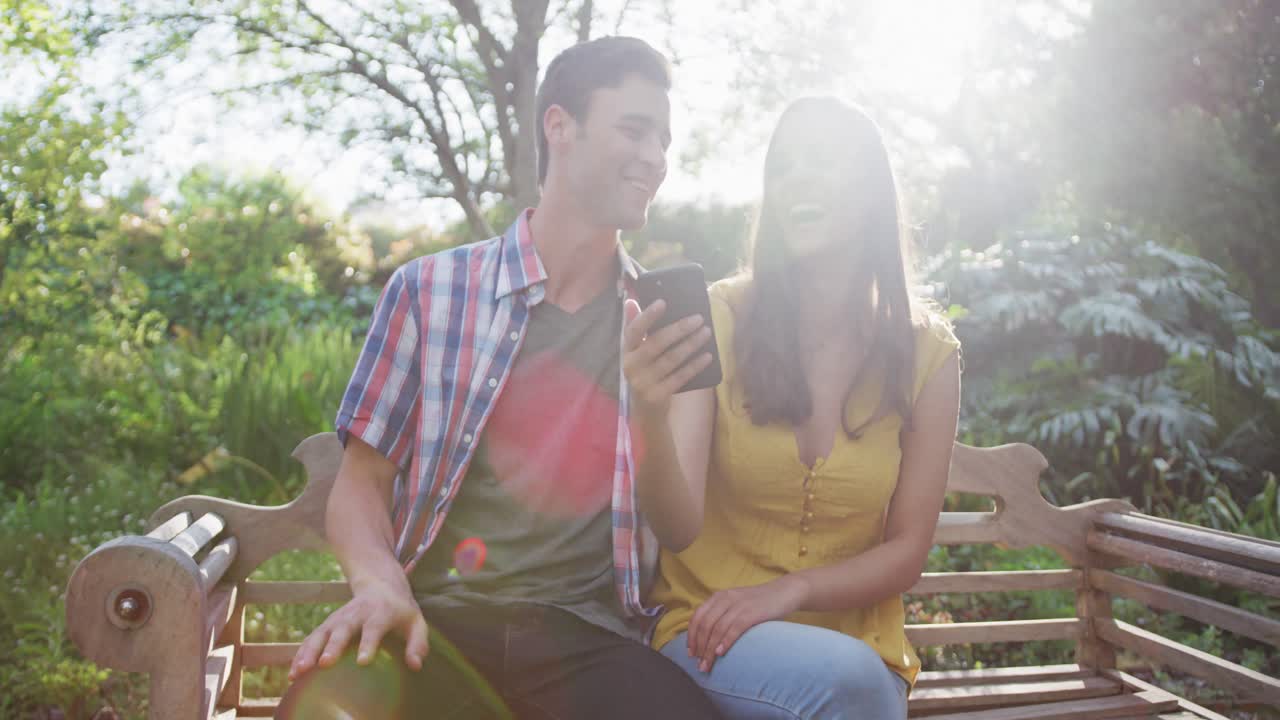 벤치 에 앉아 있는 정원 에 있는 행복 한 백인 부부