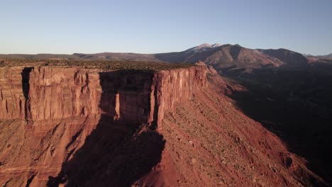 vertical sandstone cliffs of adobe mesa near moab in golden sunset