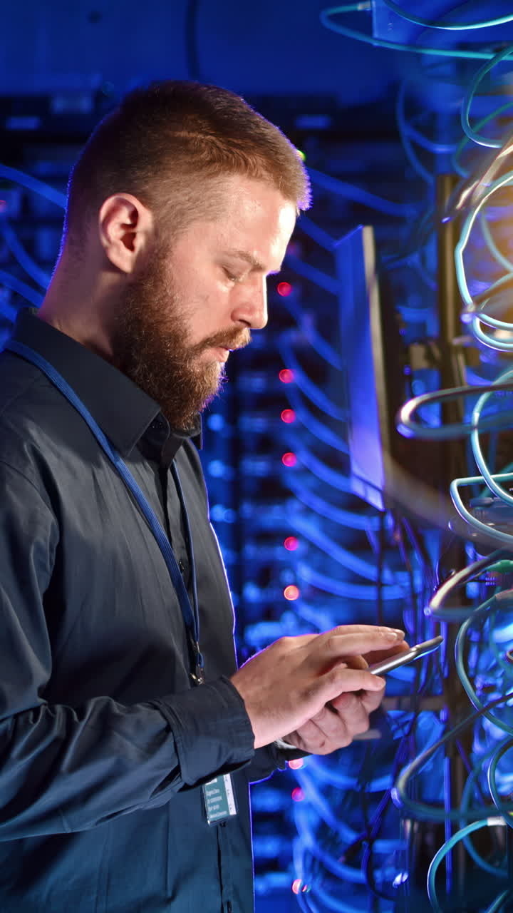 Man analysing data in a server room. Vertical