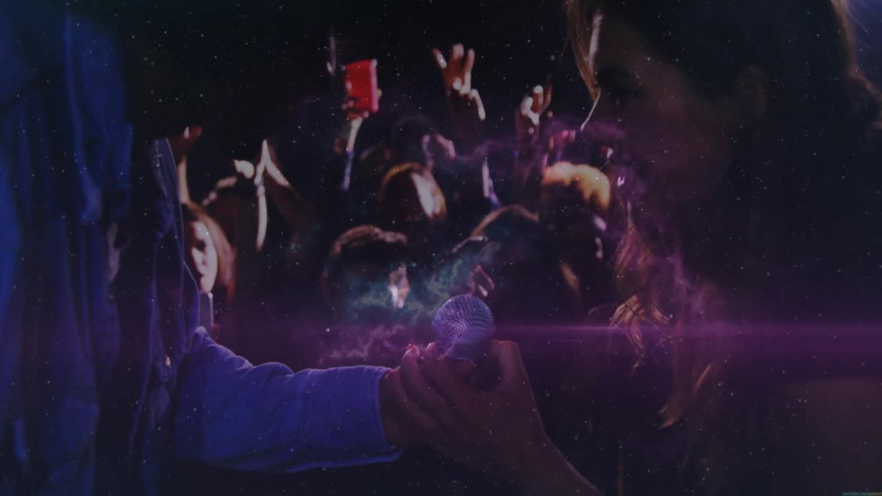 Host extending mic, singer grabbing mic singing music as crowd dancing under growing nebula visuals
