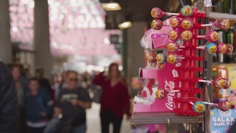 Anzeige-Von-Süßigkeiten-Vor-Geschäften-Im-Covent-Garden-Market-Mit-Touristen-In-London,-Großbritannien