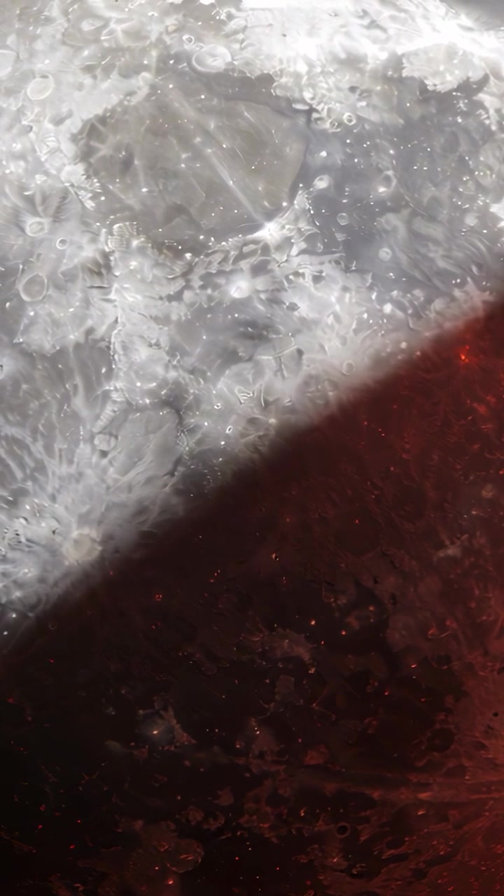 Video verticale: Spostamento del fotogramma che causa una banda scura che si muove su una superficie macro, con punti luce scintillanti.