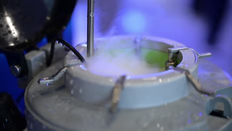 Steam-and-gases-of-liquid-nitrogen-come-from-an-open-pressure-vessel,-close-up,-blue-science-background,-chemical