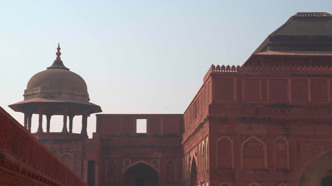 Hindistan'ın Uttar Pradesh eyaletindeki Agra Kalesi'nde bulunan kırmızı kumtaşından bir çhatri pavyonunun ve Jahangiri Mahal'in cephesinin yatay sağa kaydırma çekimi.