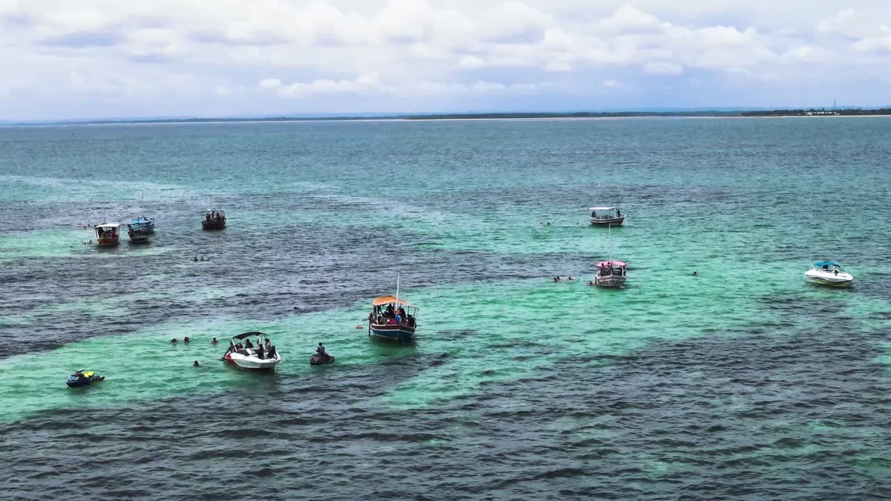 관광 보트가 있는 카라무아나스 암초의 자연 수영장의 공중 전망