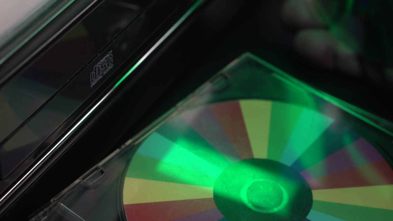 Setter CD i CD-spiller, spiller musikk i et gammelt audiosystem