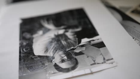 a close up shot of old, black and white portrait photographs of people from the 80s, laid out on a table.