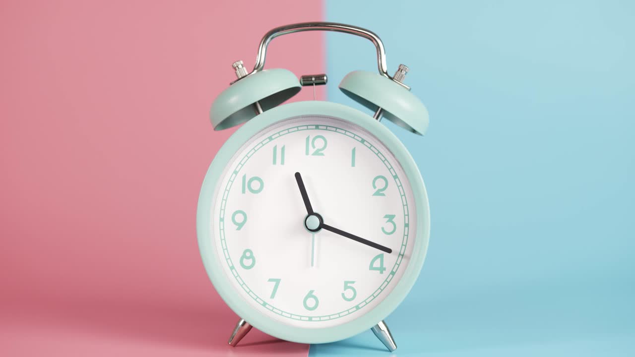 알람 시계는 분홍색 파란색 배경에 고립되어 있습니다.
