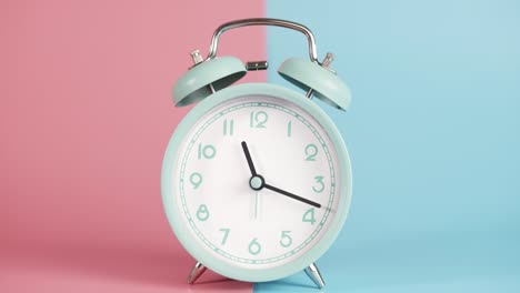 the alarm clock is isolated on a pink blue background.