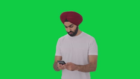 angry sikh indian man texting someone green screen