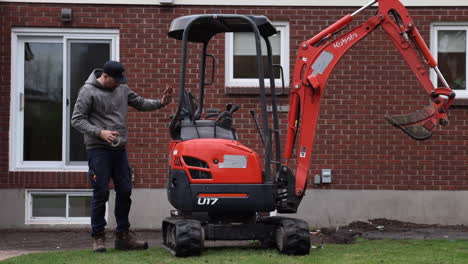 construction contractor inspecting small excavator in backyard clients house - maintaince - wide shot