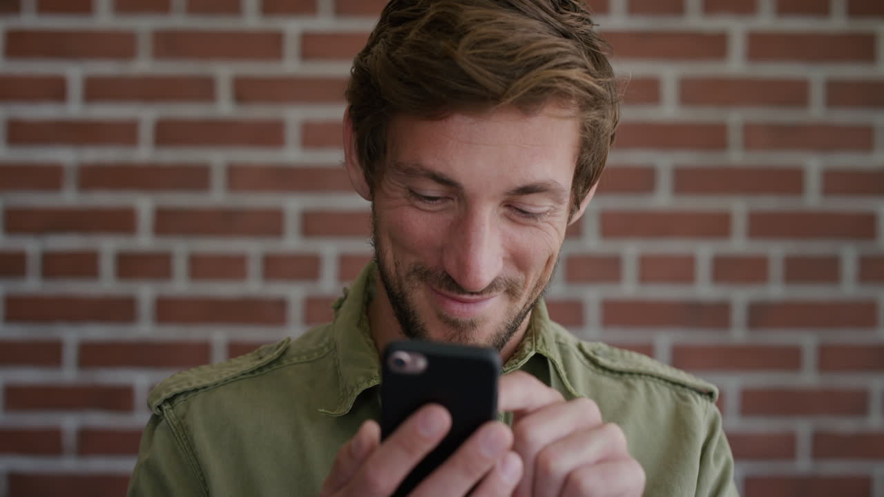 ritratto bel giovane che usa lo smartphone si gode di inviare messaggi sms navigando online uomo caucasico felice sulla tecnologia del telefono cellulare