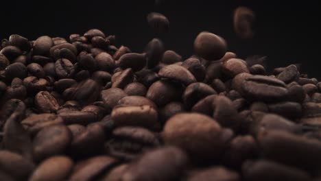 granos de café cayendo sobre fondo negro