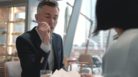 A-Business-Man-Has-A-Meeting-With-An-Unrecognizable-Woman-In-A-Cafeteria-1