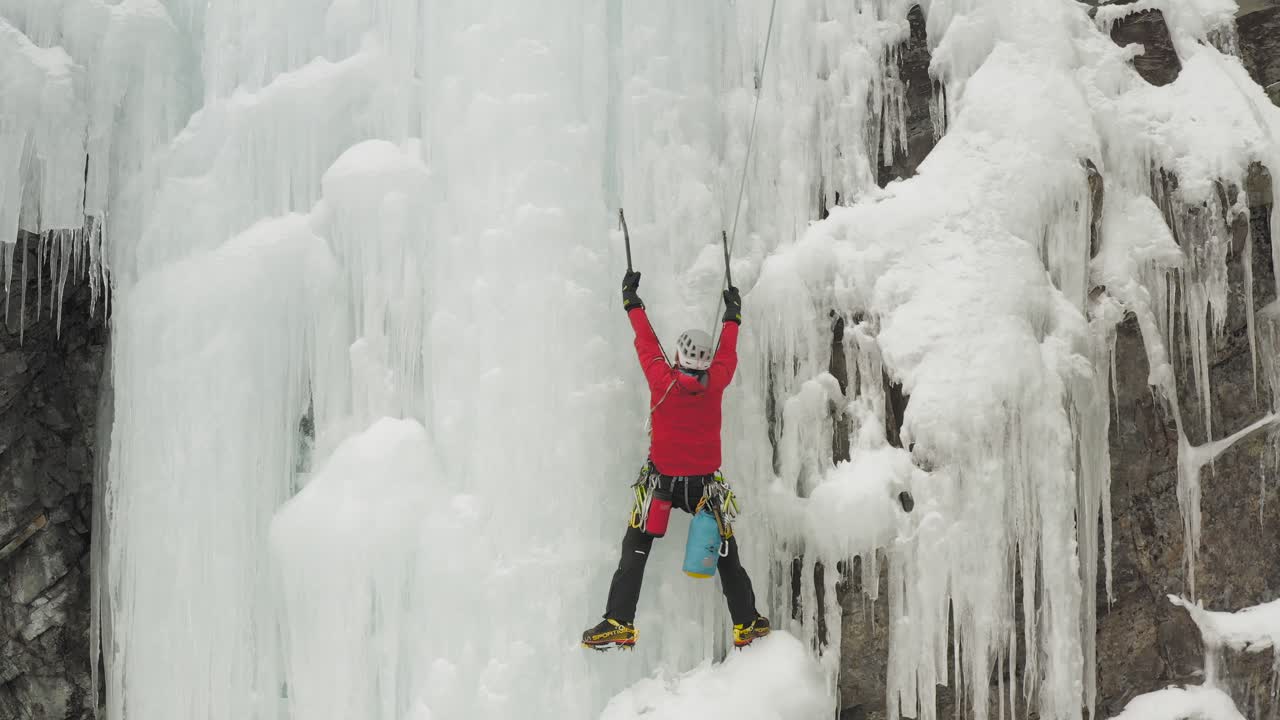 escalador solitario descansando antes de ascender al acantilado congelado monte kineo 4k