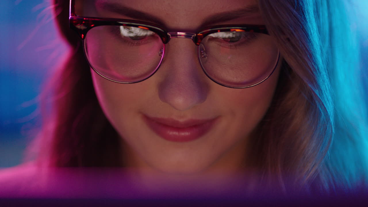 retrato de cerca de una mujer hermosa usando una tableta viendo una película por la noche mirando la pantalla disfrutando del entretenimiento en línea usando gafas