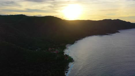 stunning sunrise drone shot of the virgin islands coastline, with a quiet peninsula basking in golden light, soft waves rolling ashore, and morning clouds glowing above the caribbean sea