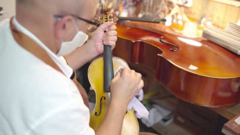 craftsman with violin in professional workshop