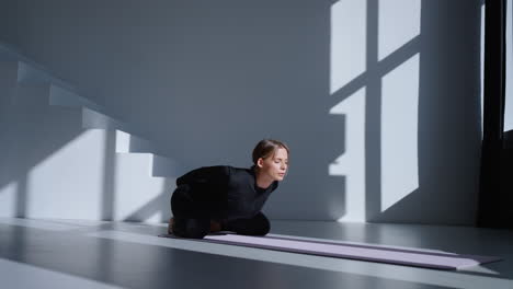 mujer practicando yoga en un estudio