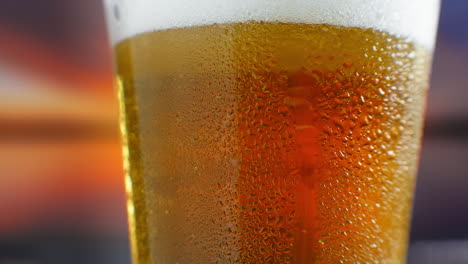 Close-up-slow-motion:-cold-Beer-in-a-glass-large-drops-and-bubbles-in-the-beer