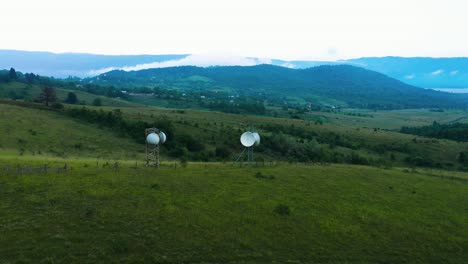 satellite dishes on green field in racha, georgia - wide orbiting shot