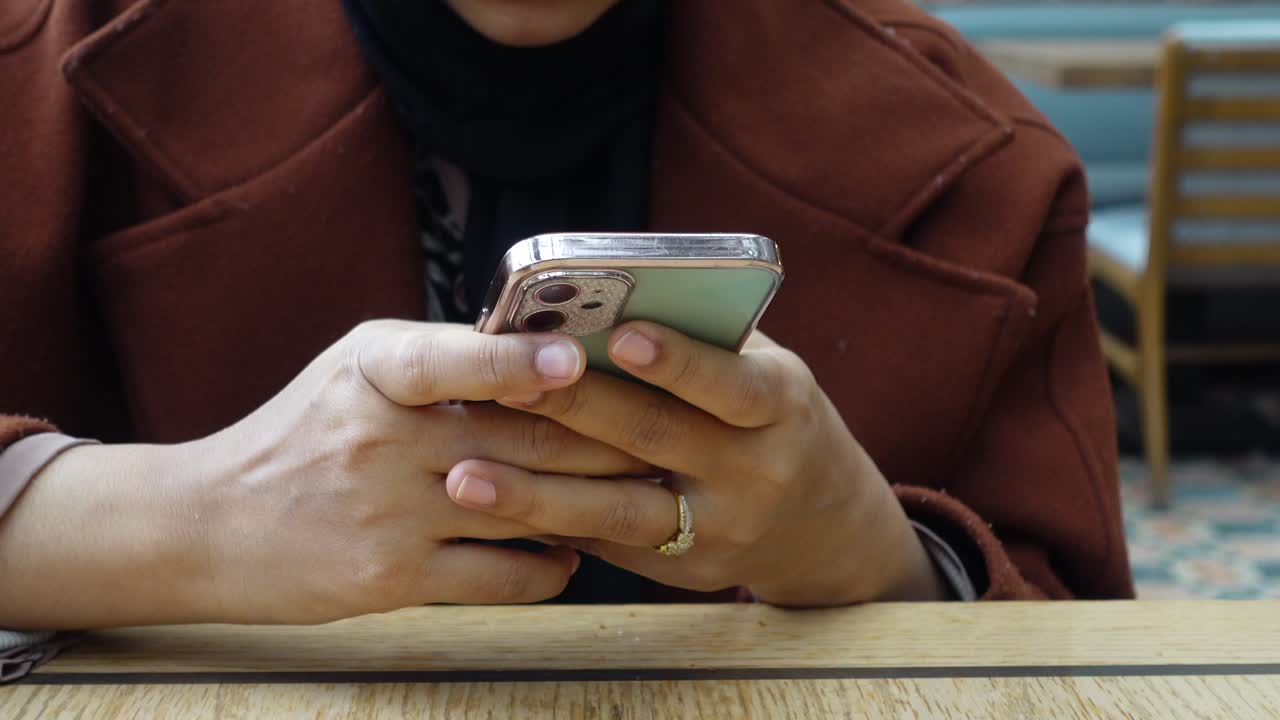 Donna seduta a un tavolo che usa il telefono