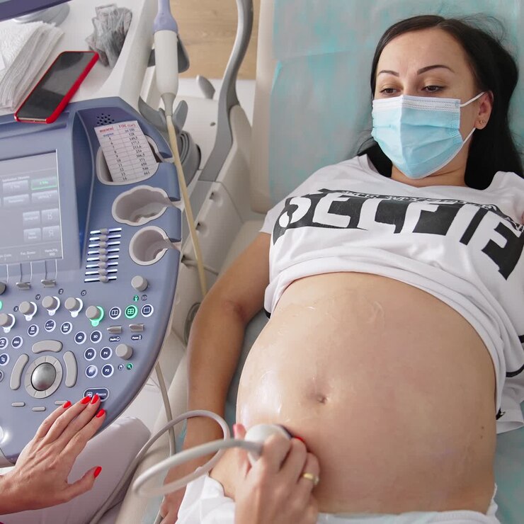 Una dottoressa esegue un'ecografia sull'addome di una donna incinta in una clinica. Screening ecografico