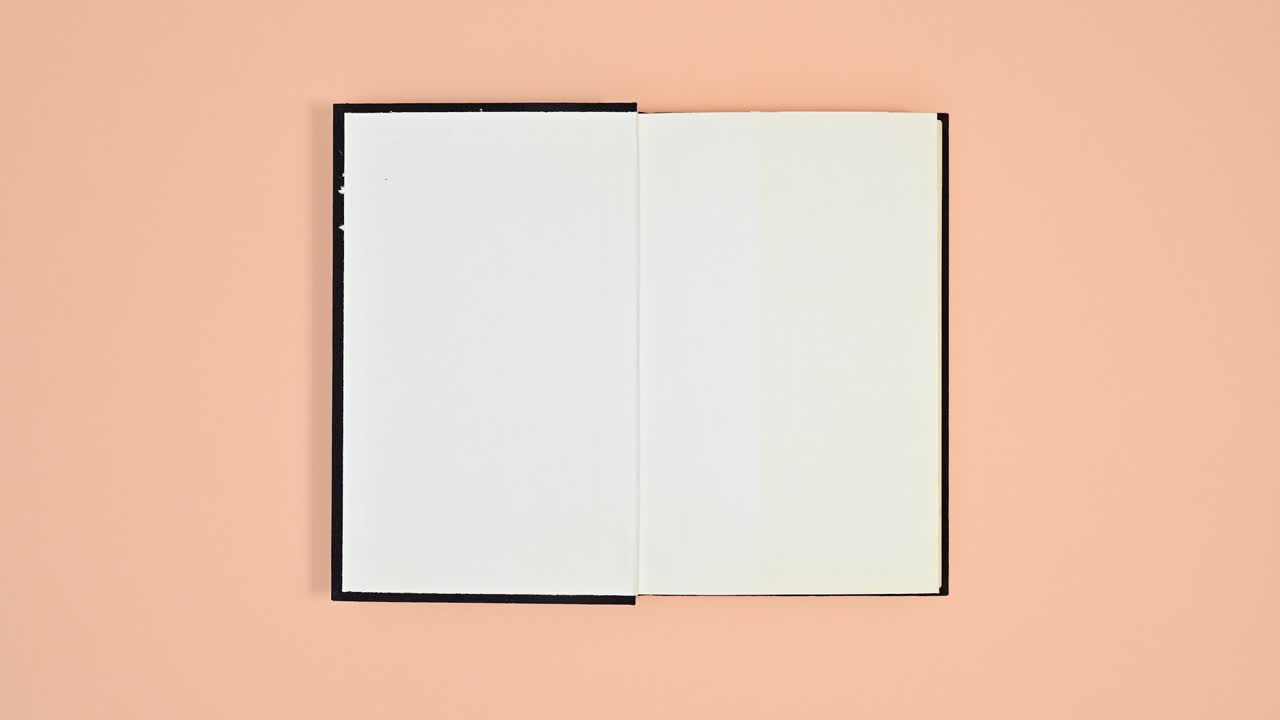 Black book changing sides and open on orange theme. Stop motion flat lay