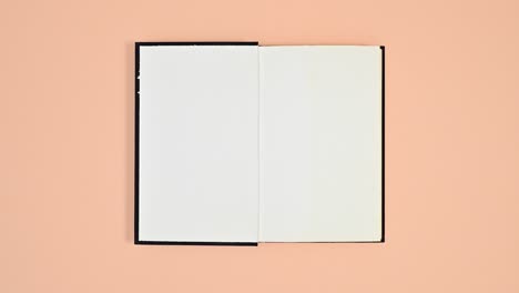 black book changing sides and open on orange theme. stop motion flat lay