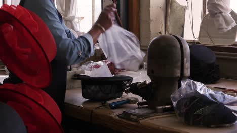 mujer de raza mixta trabajando en una fábrica de sombreros