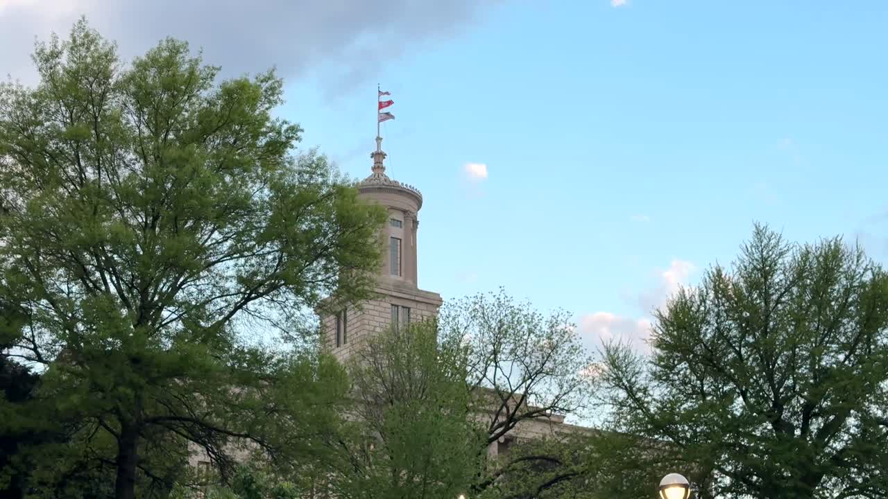 The Tennessee State Capitol building in Nashville, Tennessee with the United States flag, the Tennessee state flag
