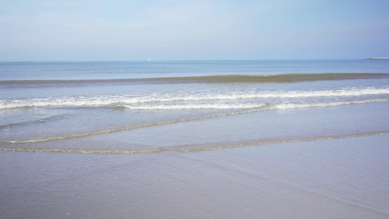 Panning shot of sea waves arriving at beach