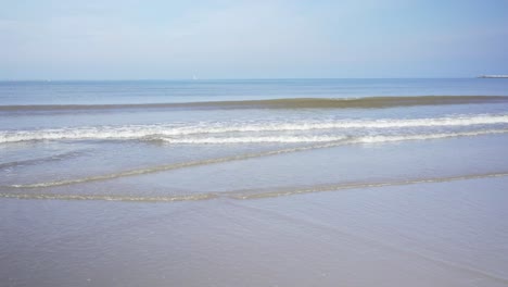 panning shot of sea waves arriving at beach