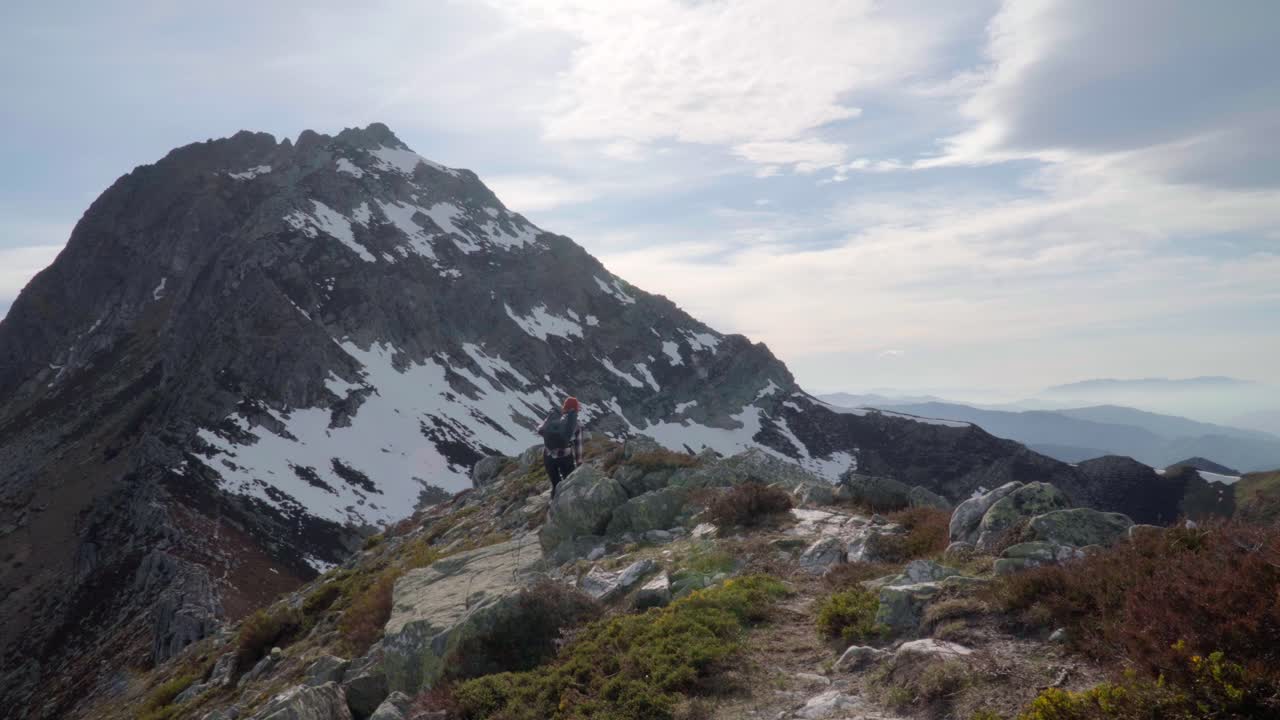Giovane donna che fa escursioni verso la cima delle Torres nei Picos de Europa nelle Asturie in una giornata di sole.