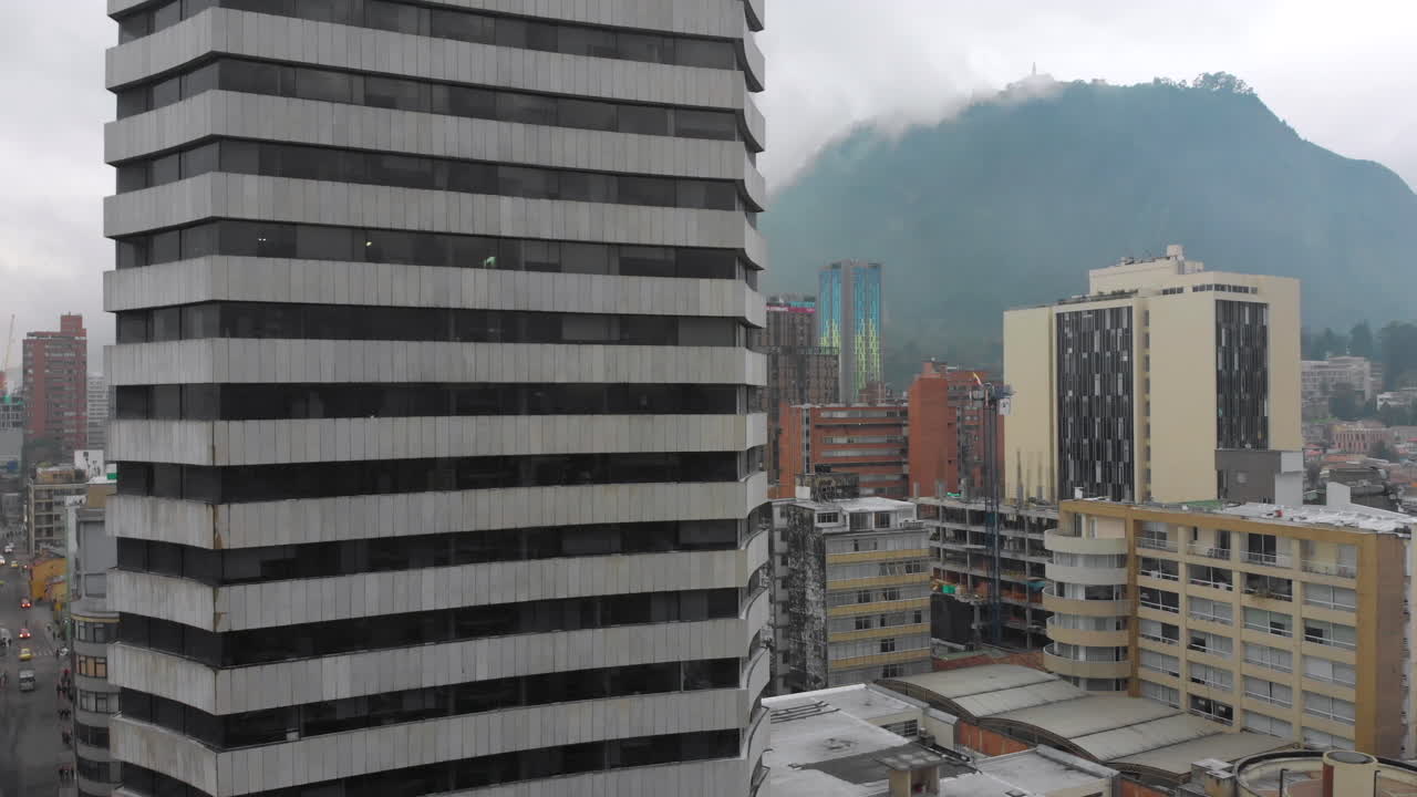edificio de gran altura en el centro de bogota con misty mountain en el fondo en colombia