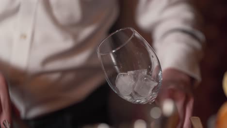 Bartender-putting-ice-cubes-into-a-glass