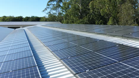 aerial drone over rows of solar panel grids on tin roof on sunny day, 4k