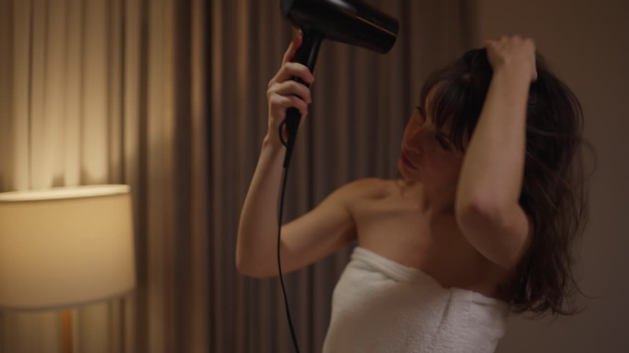 Woman drying her hair with a hair dryer