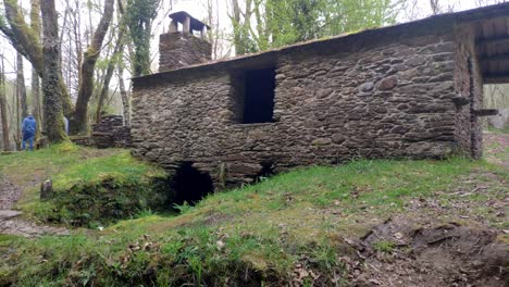 Cabaña-Refugio-En-La-Montaña-Construida-Con-Piedras-Cerca-Del-Río-Sor-Con-Gente-Visitando-La-Zona