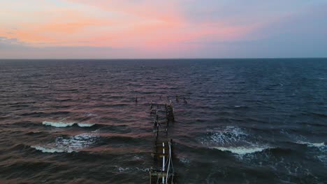aerial of the destroyed rod and reel pier in anna maria island, florida at sunset after hurricane milton.