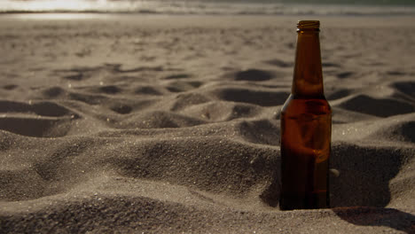 beer bottle on sand at beach 4k