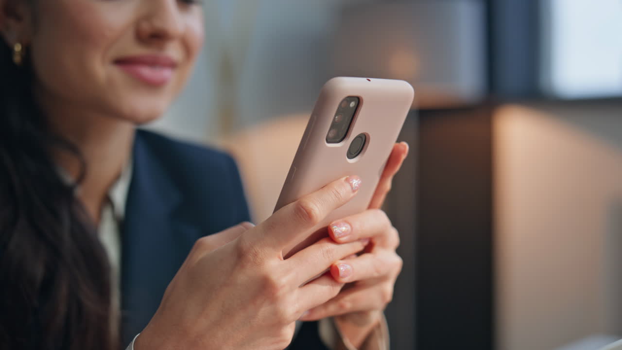 Smiling manager looking smartphone screen at modern office workplace closeup