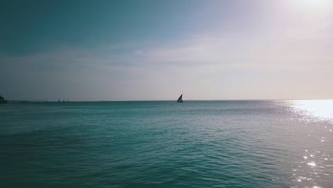 buttery soft aerial flight slowly rise up drone shot from a sailboat far out at sea sun reflection