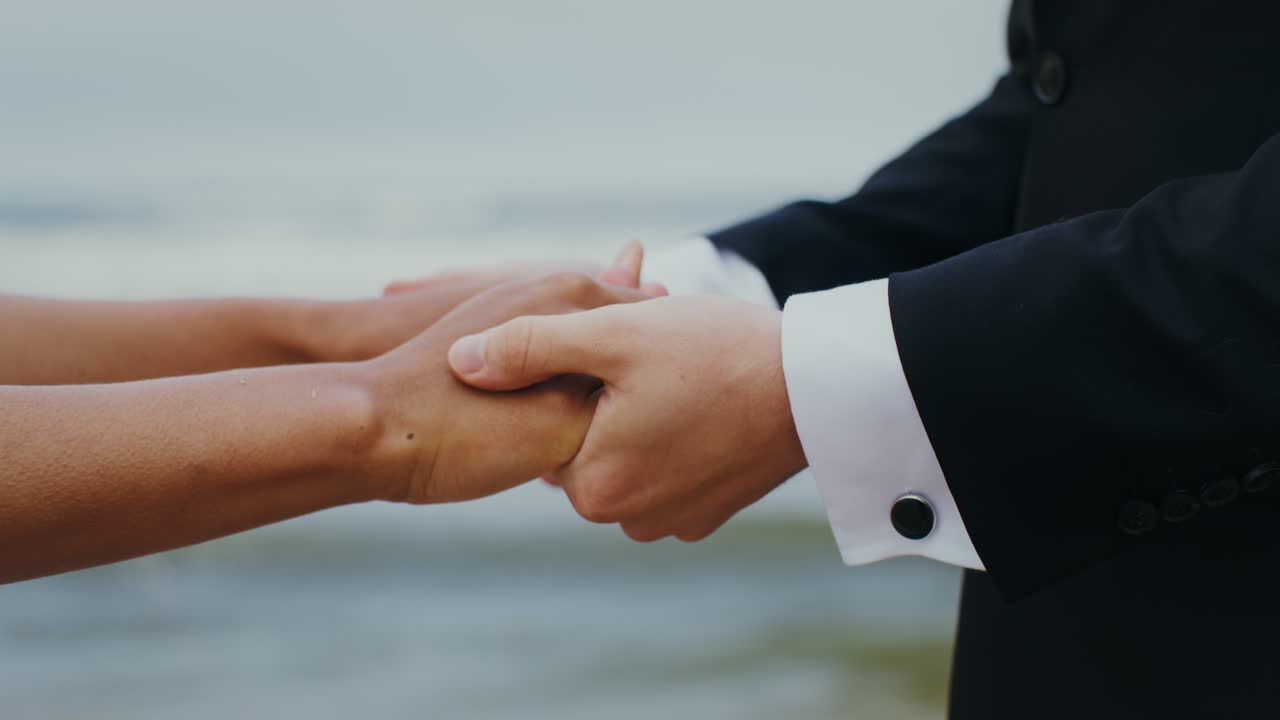 Wedding Couple Holding Hands on the Beach