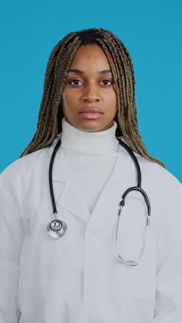 smiling female doctor with stethoscope on blue background