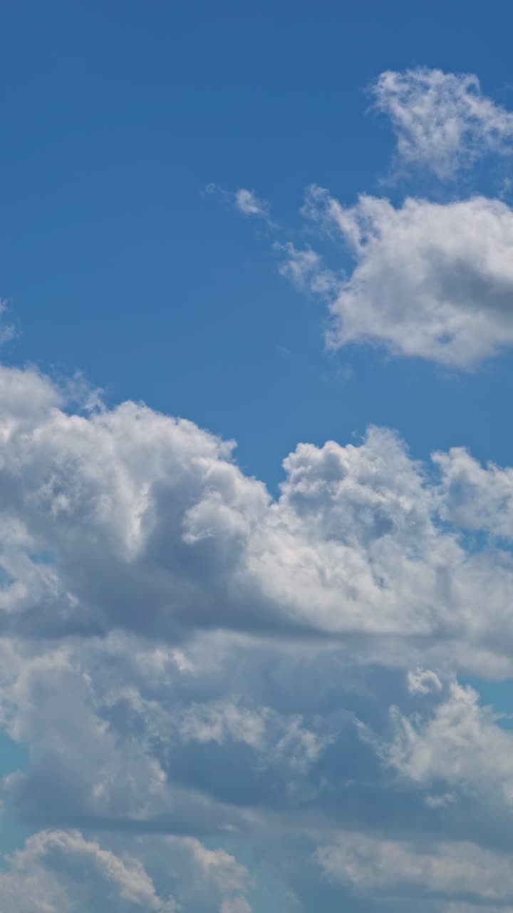 Clouds drift in the sky on a sunny day over a tranquil landscape