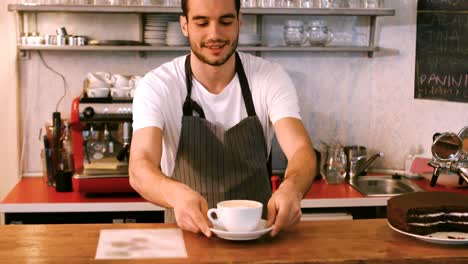 Portrait-of-smiling-waiter-standing-with-arms-crossed