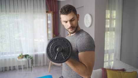 Man-Bodybuilder-Exercising-At-Home-With-Dumbbells.